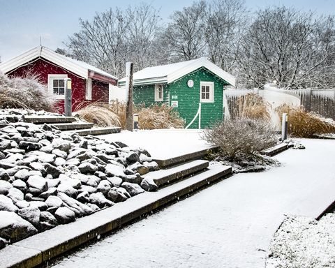 Schneebedeckte Blockhütten im Ocean Wave Saunagarten