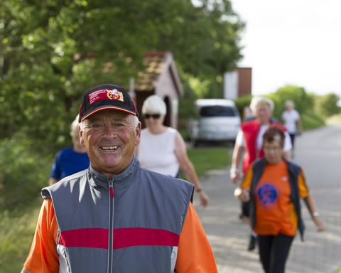 Sportlicher Spaziergang entlang der Terrainkurwege. Eine Gruppe Menschen spaziert auf einen ländlich gelegenen Weg in Norden-Norddeich.