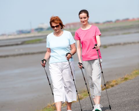 Nordic Walking in Norden Norddeich. Zwei Frauen laufen bei Ebbe auf dem Deichfuß am Watt entlang.